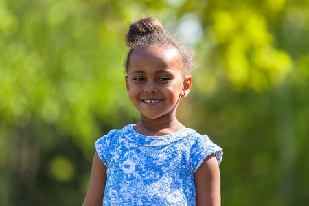 Outdoor close up portrait of a cute young black girl smiling - African peopleの写真素材