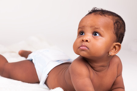 Adorable little african american baby girl  lying downの写真素材