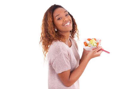 African American woman eating salad, isolated on white backgroundの写真素材