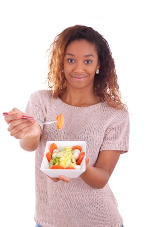 African American woman eating salad, isolated on white backgroundの写真素材