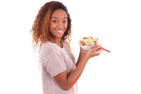 African American woman eating salad, isolated on white backgroundの写真素材