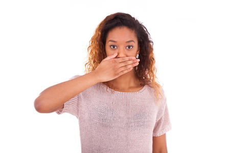 young african american covering her mouth with her hand palm isolated on white backgroundの写真素材