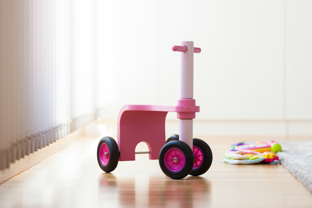 Pink wood bike toy in the middle of the living roomの写真素材