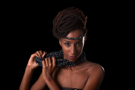 Young beautiful african woman wearing  traditional jewelry, Isolated over black background