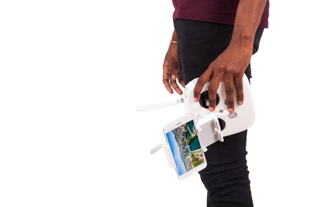 African American young man holding a drone remote control over white background