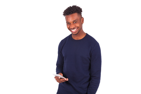 Young African American man sending a sms text message on his smartphone - Black teenager peopleの写真素材
