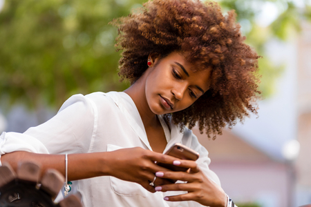 Outdoor portrait of a Young black African American young woman speaking on mobile phoneの写真素材