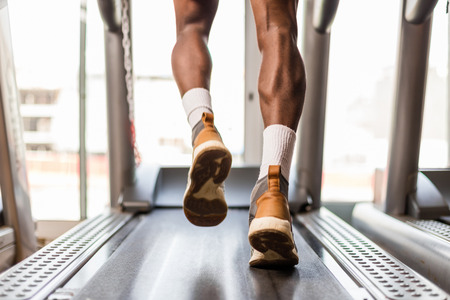 Black African American  young man doing cardio workout at the gym