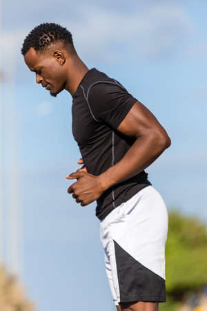 Black african american young man stretching after outdoor jogging