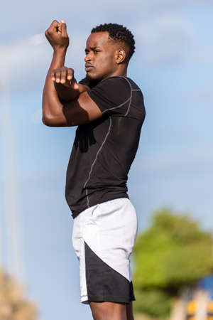 Black african american young man stretching after outdoor joggingの写真素材