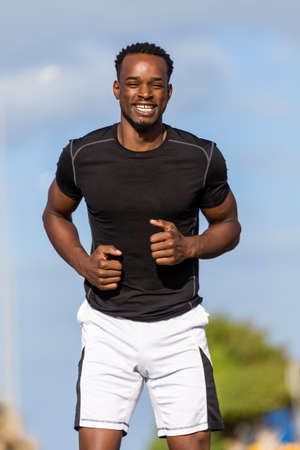Black african american young man stretching after outdoor joggingの写真素材