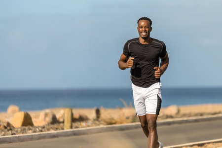 Black african american young man running outdoorの写真素材
