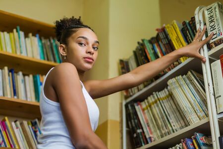 Black african american young girl student studying at the school university libraryの写真素材