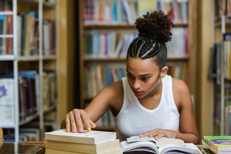 Black african american young girl student studying at the school university libraryの写真素材