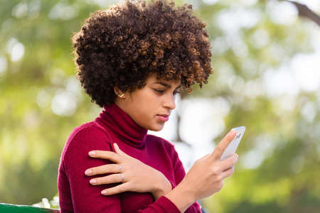 Outdoor portrait of a Young black African American young woman speaking on mobile phoneの写真素材