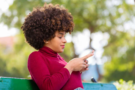 Outdoor portrait of a Young black African American young woman speaking on mobile phoneの写真素材