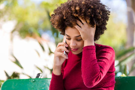 Outdoor portrait of a Young black African American young woman speaking on mobile phoneの写真素材