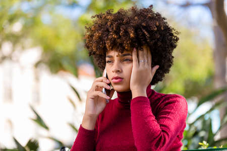 Outdoor portrait of a Young black African American young woman speaking on mobile phoneの写真素材