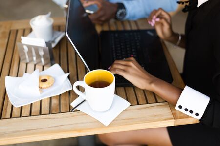 Black African American coworkers doing digital teamwork around a coffee cup