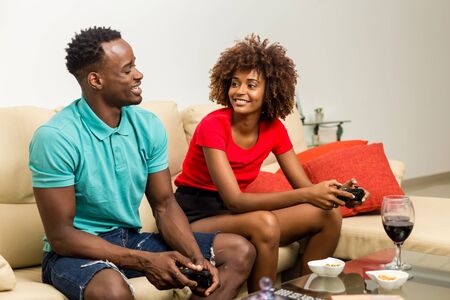 Black African American couple having fun playing video gamesの写真素材