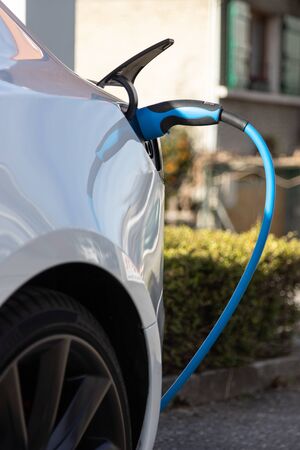 EV electric car pluged charging at a recharge station in the cityの写真素材