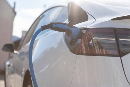 EV electric car pluged charging at a recharge station in the cityの写真素材