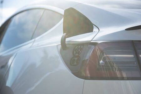 EV electric car pluged charging at a recharge station in the cityの写真素材