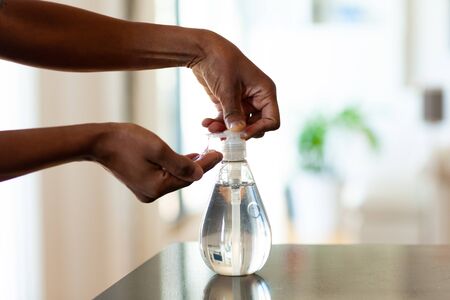 Black African American woman hand using antibacterial antiseptic hand sanitizer gelの写真素材