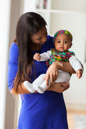 Young african american mother playing with her baby girlの写真素材