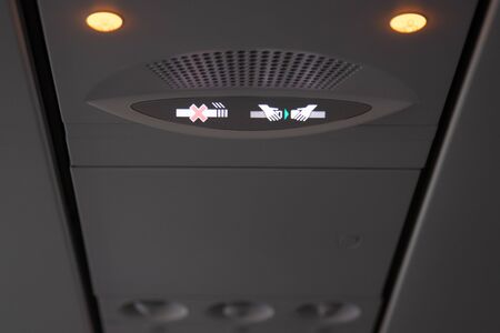 Smoking and seat belt in a airplane plane ceiling interior