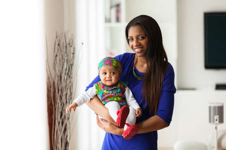 Young african american mother playing with her baby girlの写真素材