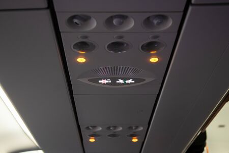 Smoking and seat belt in a airplane plane ceiling interiorの写真素材