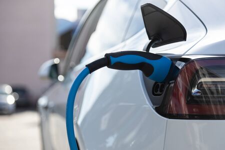 EV electric car pluged charging at a recharge station in the cityの写真素材