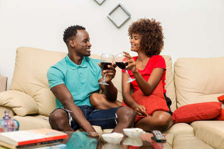 Black African American couple drinking wine in the living roomの写真素材