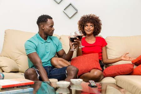 Black African American couple drinking wine in the living roomの写真素材