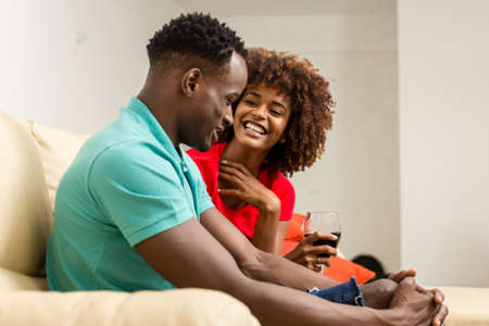 Black African American couple watching tv in the living roomの写真素材