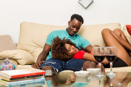Black African American couple watching tv in the living roomの写真素材