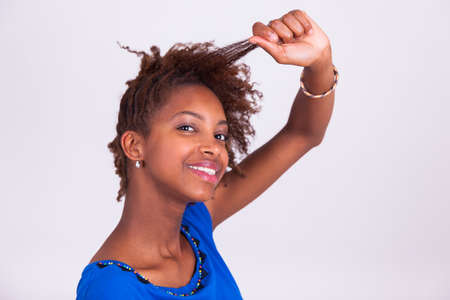 Young African American woman making braids to her frizzy afro hair - Black peopleの写真素材