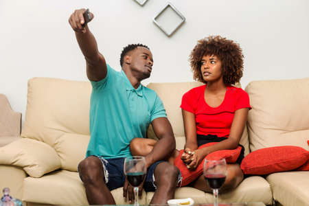 Black African American couple watching tv in the living roomの写真素材
