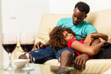 Black African American couple watching tv in the living roomの写真素材