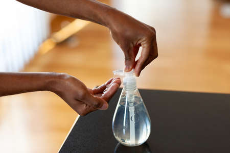 Black African American woman hand using antibacterial antiseptic hand sanitizer gelの写真素材
