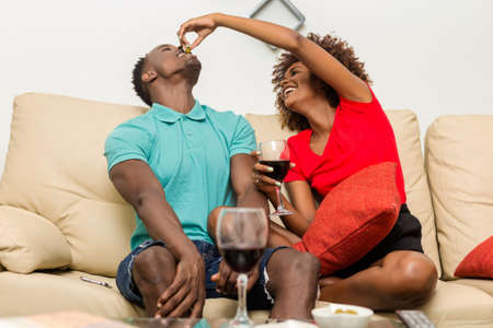 Black African American couple drinking wine in the living roomの写真素材