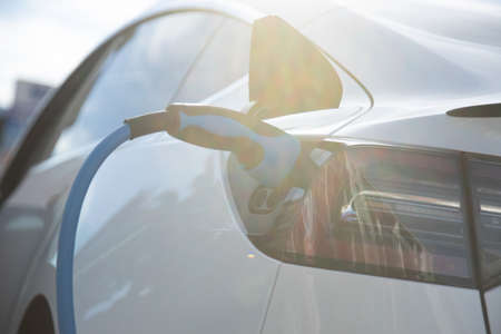 EV electric car pluged charging at a recharge station in the cityの写真素材