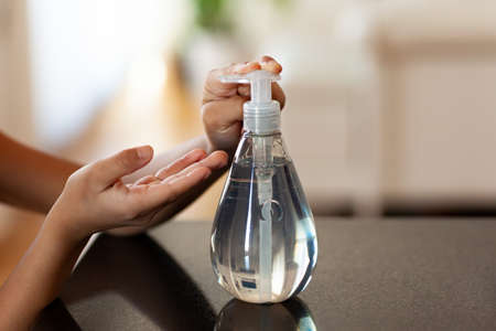 Black African American children hand using antibacterial antiseptic hand sanitizer gelの写真素材