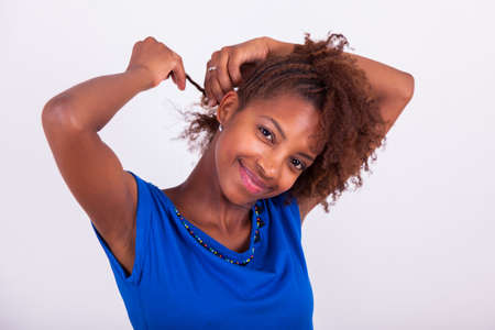 Young African American woman making braids to her frizzy afro hair - Black peopleの写真素材