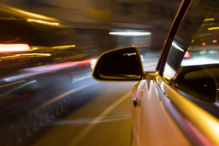 Car light trail while driving in the coty by nightの写真素材