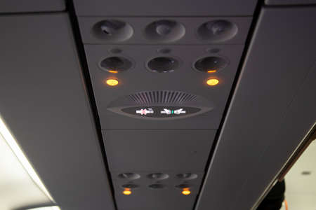 Smoking and seat belt in a airplane plane ceiling interiorの写真素材