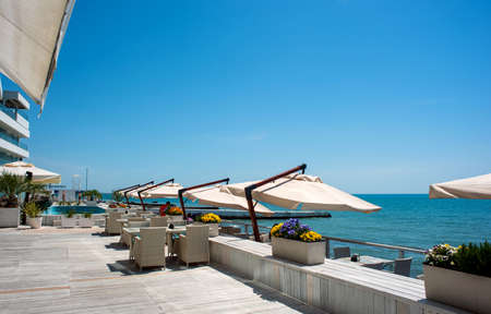 The embankment of the sea is equipped with umbrellas, flowers and pedestals for tourists to relax.のeditorial素材