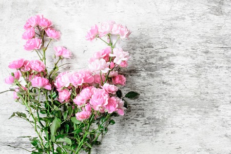 pink rose flowers bouquet on white rustic wooden background for creative work design. top view. vintage toningの写真素材