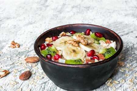 bowl of homemade fruit oatmeal for healthy breakfast on rustic wooden background with copy space. close upの写真素材